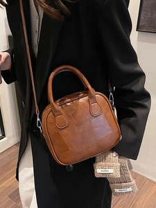 Brown vintage leather crossbody bag with geometric texture shown on a female model