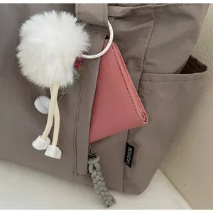 Macro shot of nylon tote bag showing the zippered front pocket and large storage capacity
