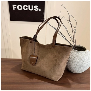 Detail of vintage matte tote bag with leather handles on a wooden table setting