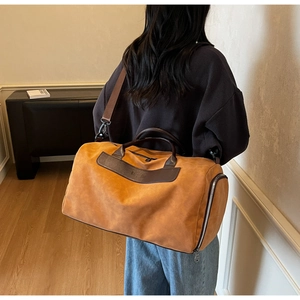 Detail view of large suede travel bag with shoe compartment and adjustable shoulder strap