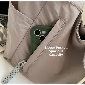 Close-up of the back zipper pocket on nylon tote bag showing interior phone storage space