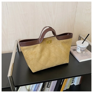 Detail of suede tote bag featuring quilted diamond pattern and gold-tone twist lock