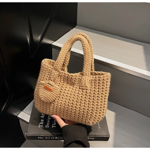 Macro view of camel knit handbag showing honeycomb texture and Hand Made leather tag