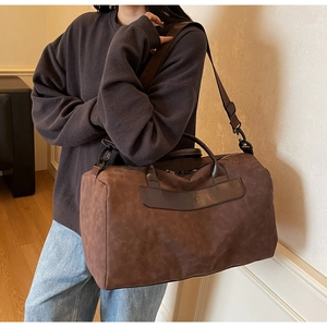 Close-up of large travel bag with brown faux suede texture and separate shoe compartment