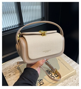 Dettaglio della borsa beige con trama intrecciata e fibbia dorata a conchiglia