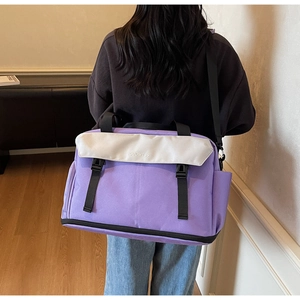 Purple and cream canvas travel bag with adjustable strap worn by model in a cozy room