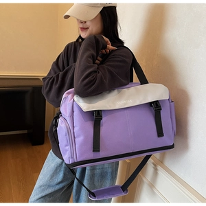 Detail view of purple travel bag featuring durable fabric with gray flap and buckle closure