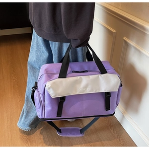 Detail of purple travel tote bag with adjustable shoulder strap and color-block design