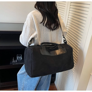 Detailed view of the large capacity travel bag with leather handles and metal hardware