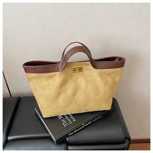 Detailed macro view of ginger suede tote bag featuring quilted pattern and gold twist lock