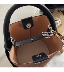 Detail view of the secure magnetic snap closure and brown suede bucket bag interior