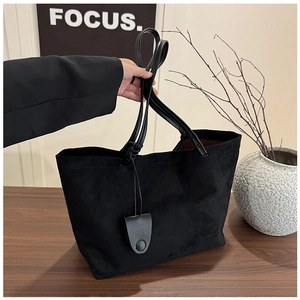 Detail of the black matte tote bag featuring soft suede texture and leather straps