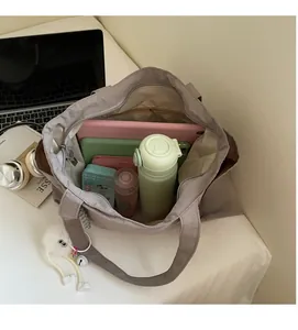 Spacious interior of the nylon tote bag showing a 14-inch laptop and storage compartments