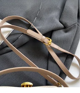 Dettaglio della tracolla in pelle beige regolabile con fibbia dorata sulla borsa