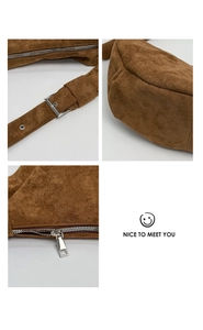 Detail view of brown suede bag with silver buckle, zipper, and adjustable strap