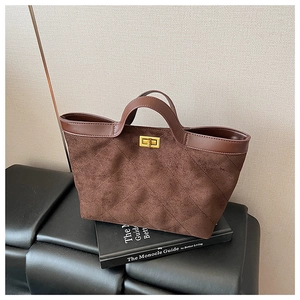 Close-up of vintage brown suede tote bag with quilted stitching and gold twist lock