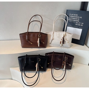 Detail view of four textured tote bags in brown, white, black and dark coffee colors