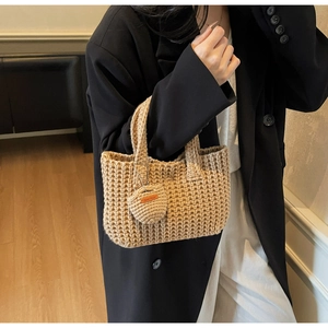 Detail of handmade knit tote bag with heart charm and Hand Made leather label