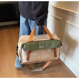Detail of a large canvas travel bag showing the adjustable strap and buckles
