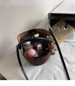 Large capacity of the brown suede bucket bag showing storage for umbrella and cosmetics