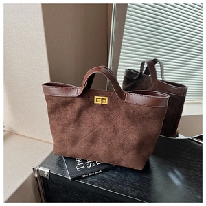 Detail of coffee brown suede tote bag featuring quilted diamond pattern and gold metal clasp