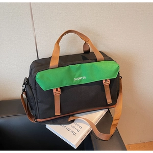 Detail view of large travel bag featuring green flap, black canvas and adjustable strap