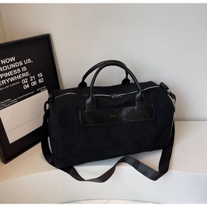 Detail of travel bag leather handles and adjustable shoulder strap with Moon Bag logo