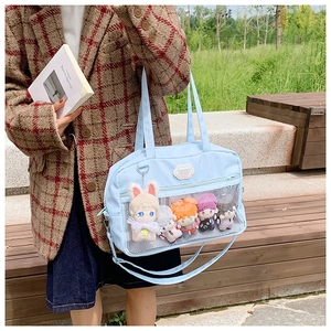 Dettaglio borsa ita azzurra con tasca trasparente a rete e bambole di peluche
