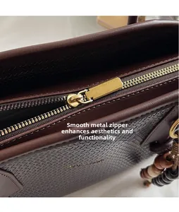 Macro shot of smooth gold metal zipper and woven texture on dark brown tote bag