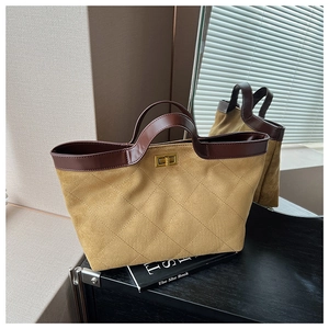 Detail of vintage quilted suede tote bag with brown leather trim and golden twist lock