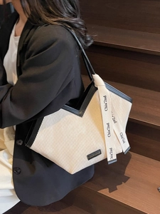 Fashionable off-white pleated tote bag with black trim and printed ribbon detail