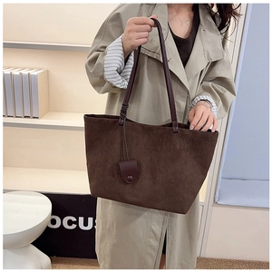Macro shot of large dark brown matte suede tote bag showing texture and side strap detail