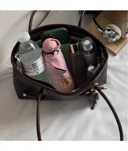 Spacious interior of dark brown pebbled leather tote bag holding everyday essentials
