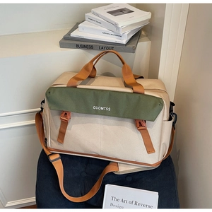 Detail of multi-functional travel bag featuring ivory canvas with olive green flap design