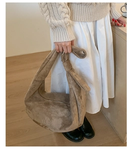 Detail of khaki suede hobo bag showing its soft texture and silver zipper closure