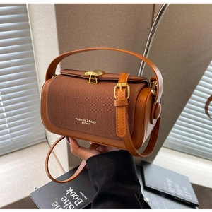 Dettaglio borsa a cilindro marrone vintage con chiusura in metallo e finitura in pelle