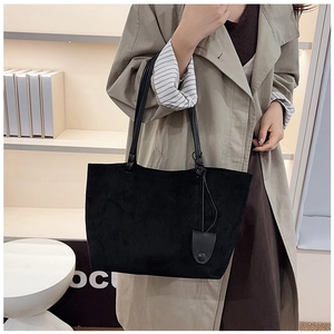 Detail shot of black frosted tote bag on a model featuring spacious interior and minimalist style