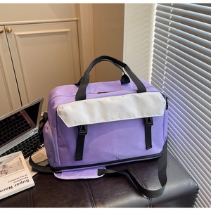 Detail view of purple nylon travel bag with adjustable strap on a leather bench