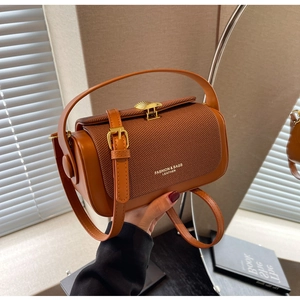 Dettaglio di borsa vintage in pelle marrone e tessuto con fibbia dorata a ventaglio