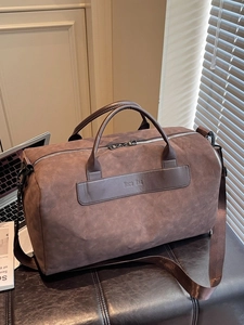 Large dark brown travel duffel bag with separate shoe compartment and adjustable shoulder strap