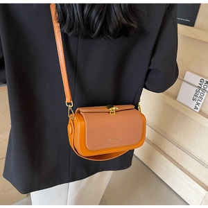 Dettaglio borsa a tracolla vintage arancione con trama intrecciata e chiusura a girello oro