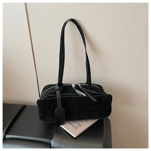Detail of minimalist black suede pillow bag with dual zippers and long leather pull tabs