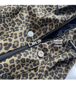 Close-up of leopard print tote featuring smooth silver metal zipper and magnetic buckle