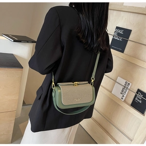 Dettagli dei bordi in pelle verde e patta intrecciata su una piccola borsa a tracolla