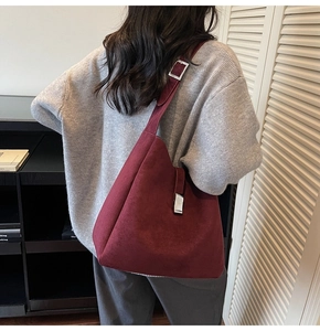 Burgundy oversized suede hobo bucket bag with silver buckle worn by model