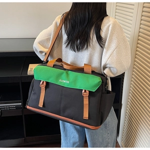 Detail view of large travel bag with green flap and adjustable shoulder straps on model