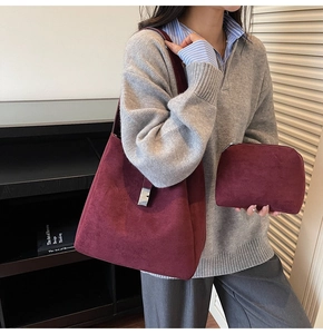 Detail of burgundy suede tote bag set with silver buckle and wide shoulder strap