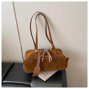 Detail of vintage brown suede pillow bag featuring a long leather tassel and chic pendant