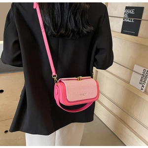 Dettaglio della borsa a tracolla magenta con patta intrecciata e fibbia in oro