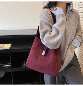 Detail of burgundy suede tote bag featuring a polished silver metallic buckle closure